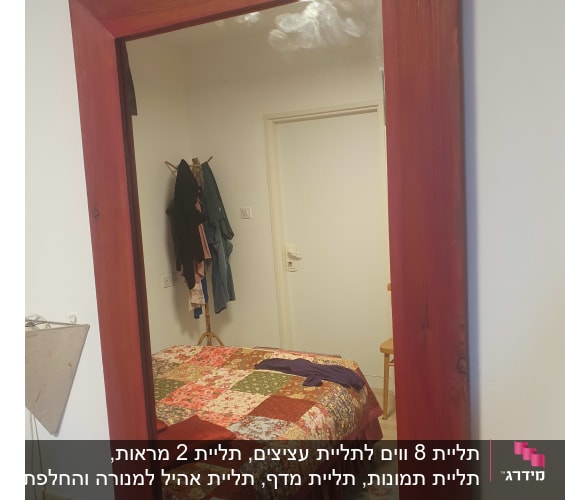 מראה עם מסגרת עץ בחדר שינה